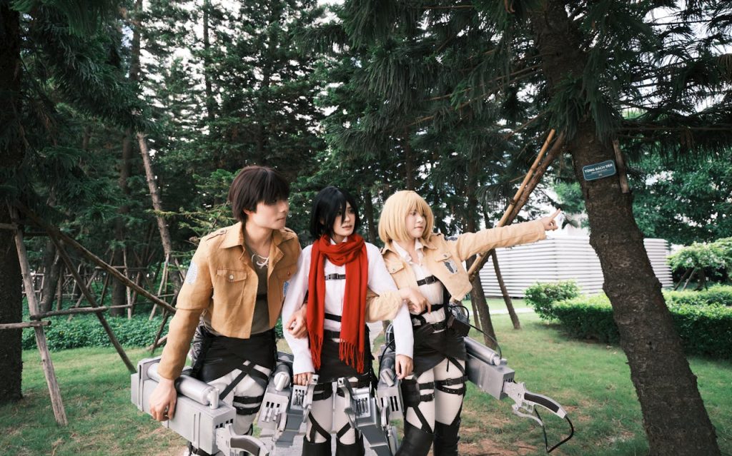 anime-cosplayers-in-forest-setting-32764753 Three anime cosplayers in action poses in a forest park setting.
